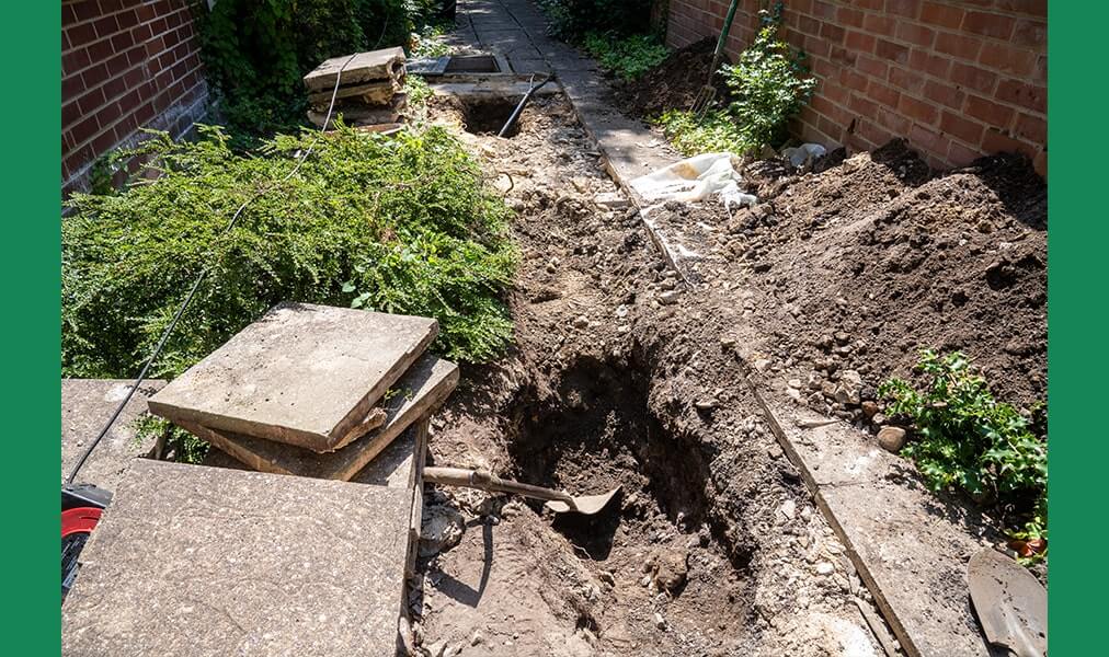 Removing soil to get to the damaged drain